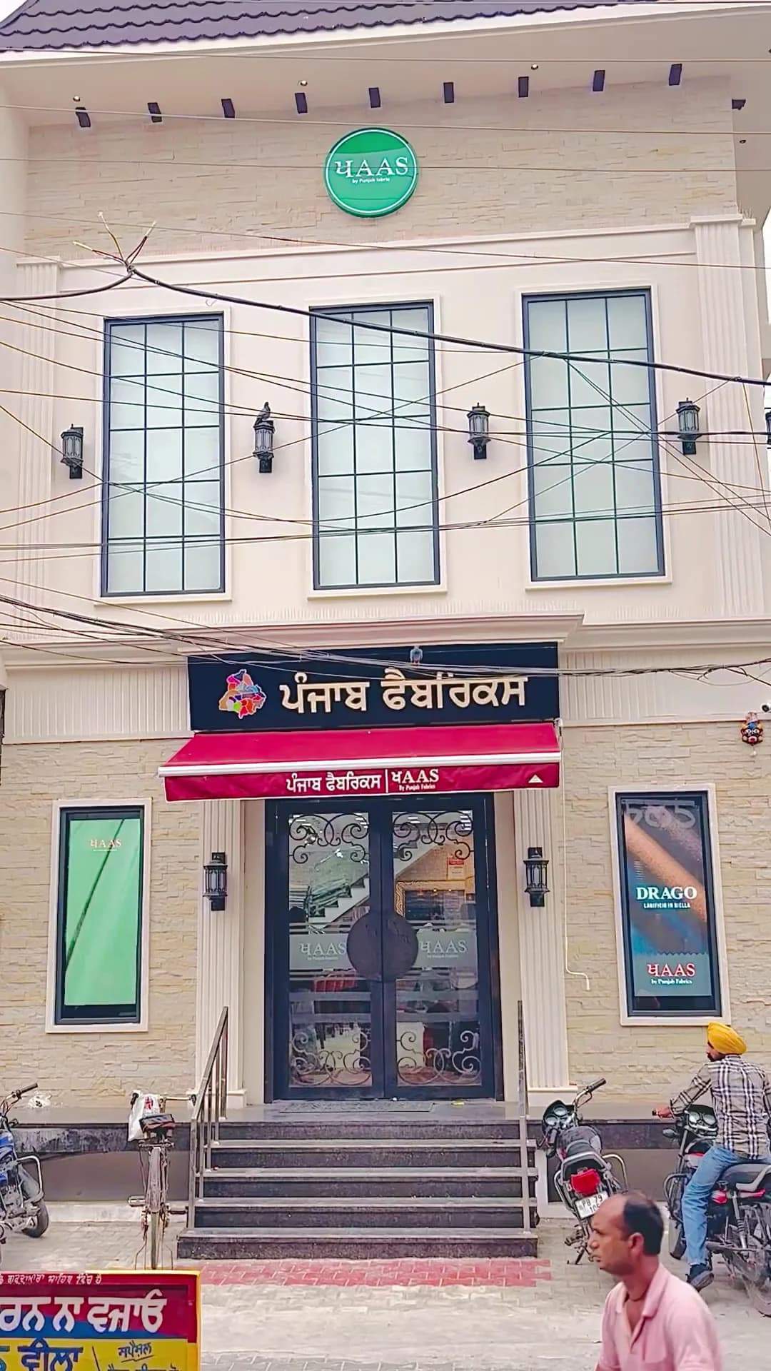 Punjab Fabrics under its red awning — the Drago and Cerruti windows either side of the door.
