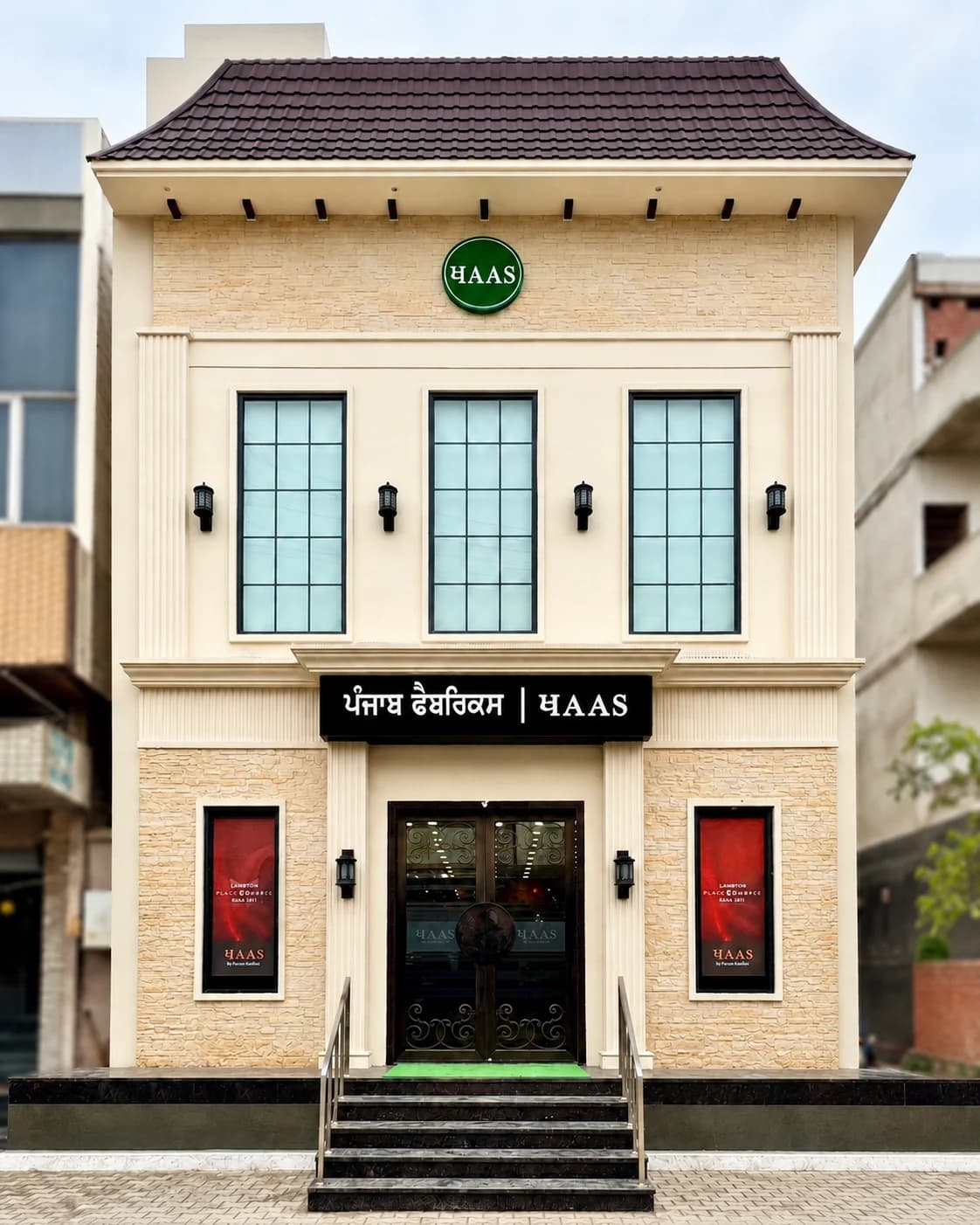 The Punjab Fabrics building on Jaitu Road — ivory stone, black signage, the green ਖAAS roundel.